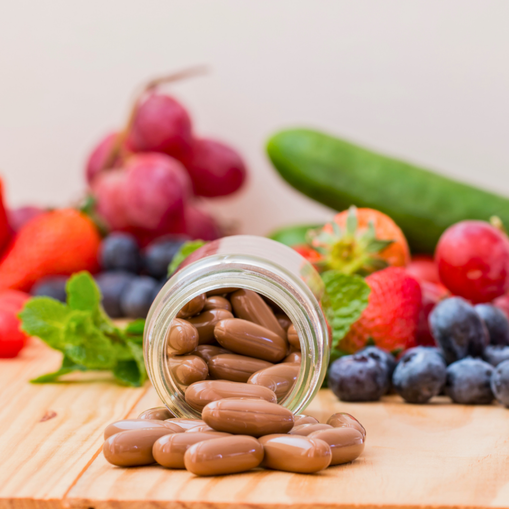 Staklenka s biljnim kapsulama razasuta uz svježe voće i povrće – prikaz dodataka prehrani poput Forever Daily koji kombiniraju vitamine, minerale i fitonutrijente za optimalnu podršku zdravlju i vitalnosti, u skladu s promjenom životnog stila.