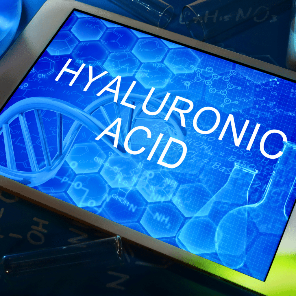 Digitalni prikaz s natpisom "Hyaluronic Acid" (hijaluronska kiselina) uz znanstvene elemente poput DNA spirale i kemijskih formula – ilustracija koja naglašava važnost hijalurona za hidrataciju kože i zdravlje zglobova. Kapsule poput Forever Active HA iz Forever Living linije sadrže hijaluronsku kiselinu niske molekularne mase i pomažu usporiti starenje organizma.