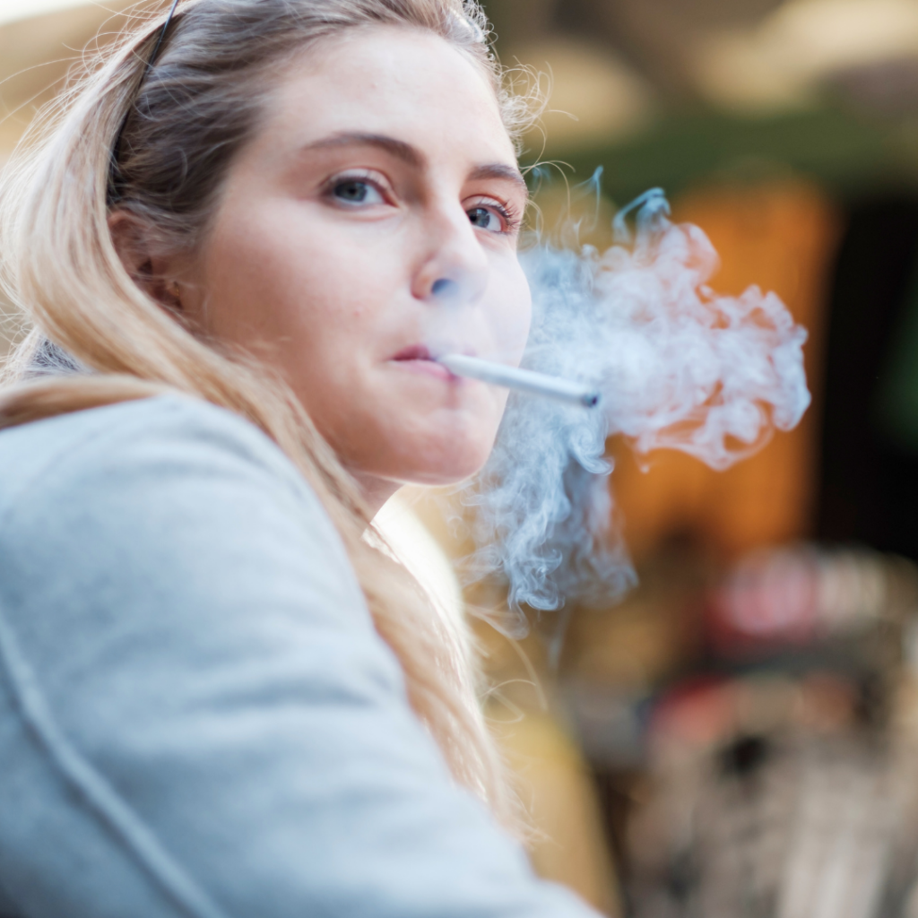 Žena puši cigaretu – pušenje je jedan od glavnih čimbenika rizika za nastanak duboke venske tromboze i bolesti krvožilnog sustava.