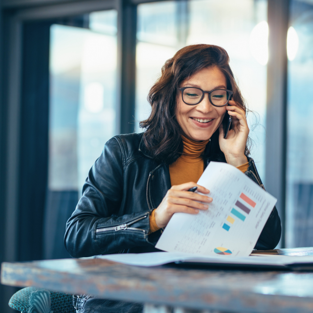 Žena proučava poslovne grafikone i razgovara telefonom, ilustracija provjere kompanije i poslovnog modela u mrežnom marketingu kako bi se izbjegla MLM prevara.