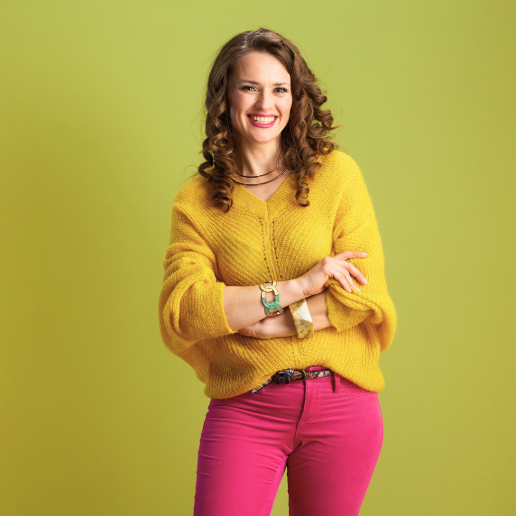 Našmijana žena u žutom puloveru simbolizira ravnotežu hormona i samopouzdanje koje dolazi kada žena upozna i razumije svoje tijelo.