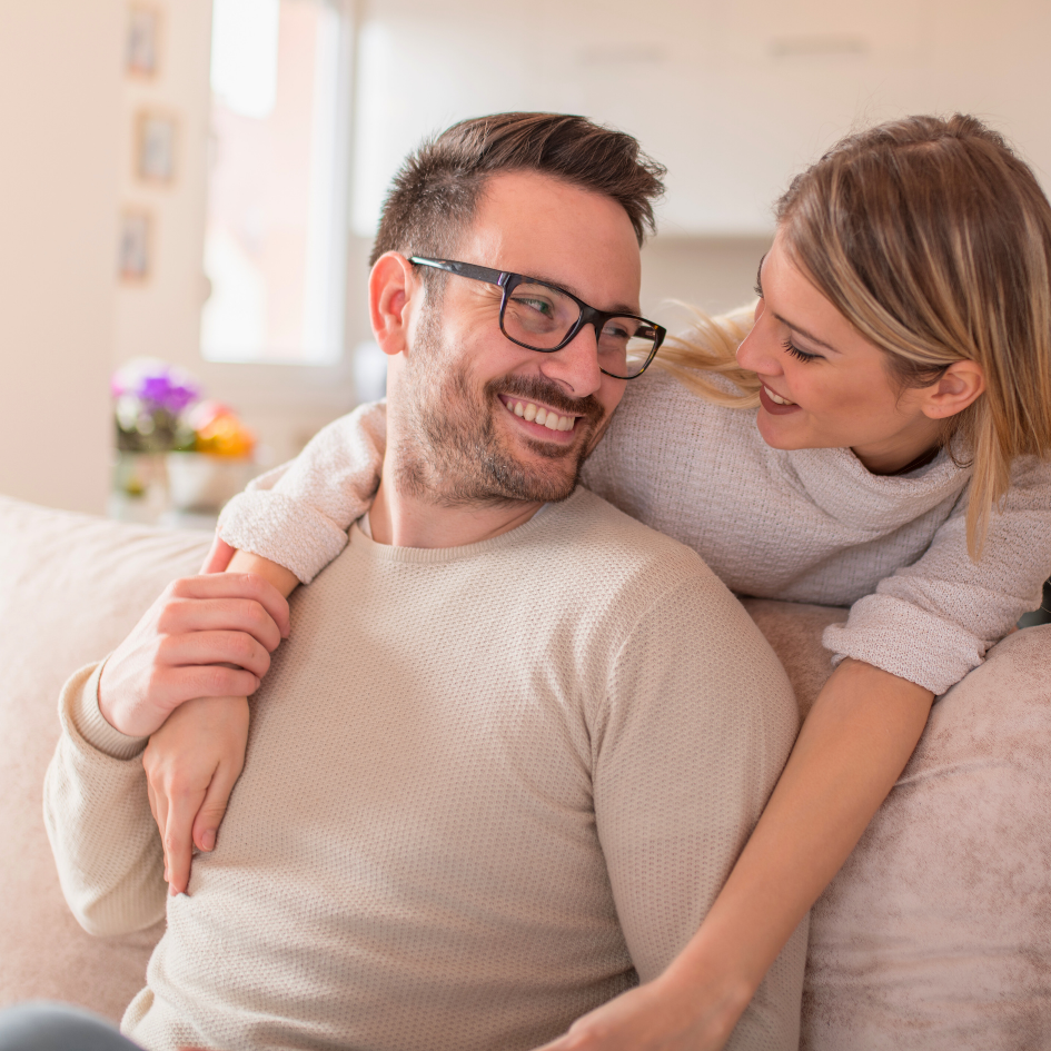 Sretan par u zagrljaju na kauču – prikaz emocionalne povezanosti i važnosti brige o srcu kroz ljubav, podršku i zdrav način života.