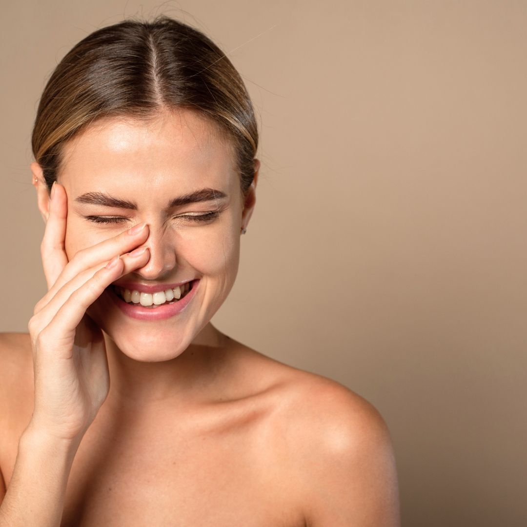 Žena sa zdravom i blistavom kožom lica koja se smije – prikaz elastične, hidratizirane kože postignute prirodnom njegom uz vitamin C i bakuchiol.