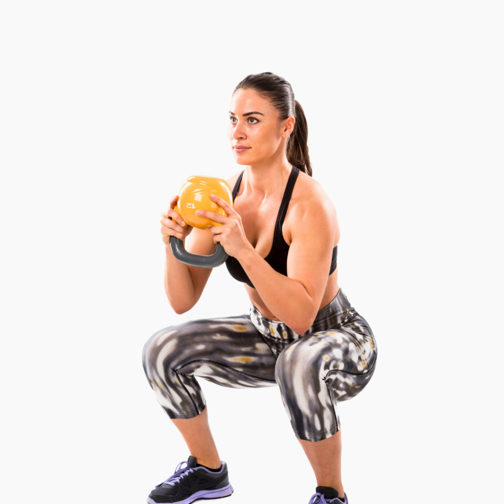 Žena izvodi goblet čučanj s girjom kao dio druge faze rehabilitacije nakon operacije prednjeg križnog ligamenta, fokus na jačanju kvadricepsa i kontroli pokreta koljena.