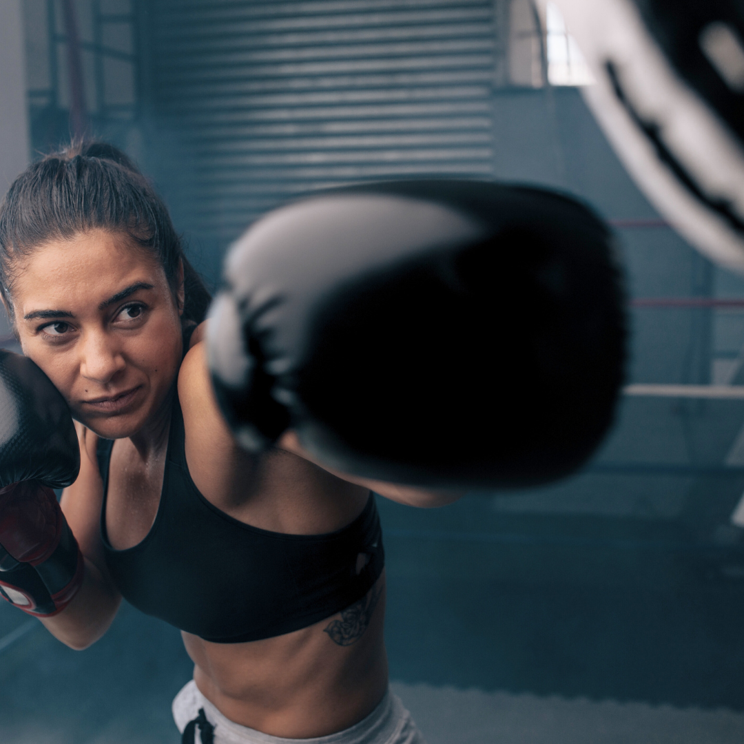 Zagreb boks fitness trening – rekreativka izvodi boksački udarac na boksačkoj vreći tijekom individualnog boks fitness treninga.