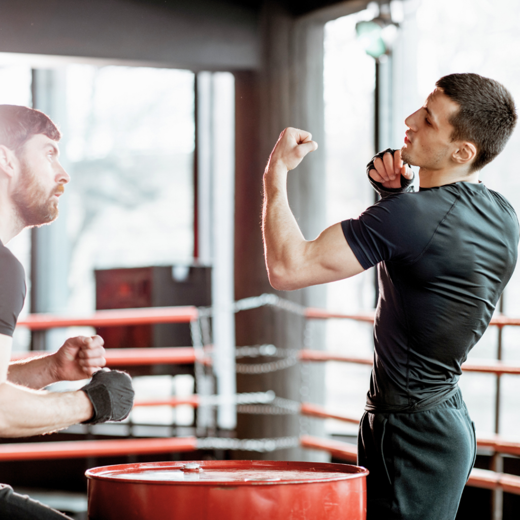 Individualni boks fitness coaching – osobni trener pokazuje pravilno izvođenje udaraca i pokreta za brži napredak