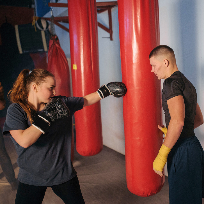 Individualni boks fitness trening Zagreb, žena ući pravilnu tehniku boksa uz pomoć osobnog trenera.