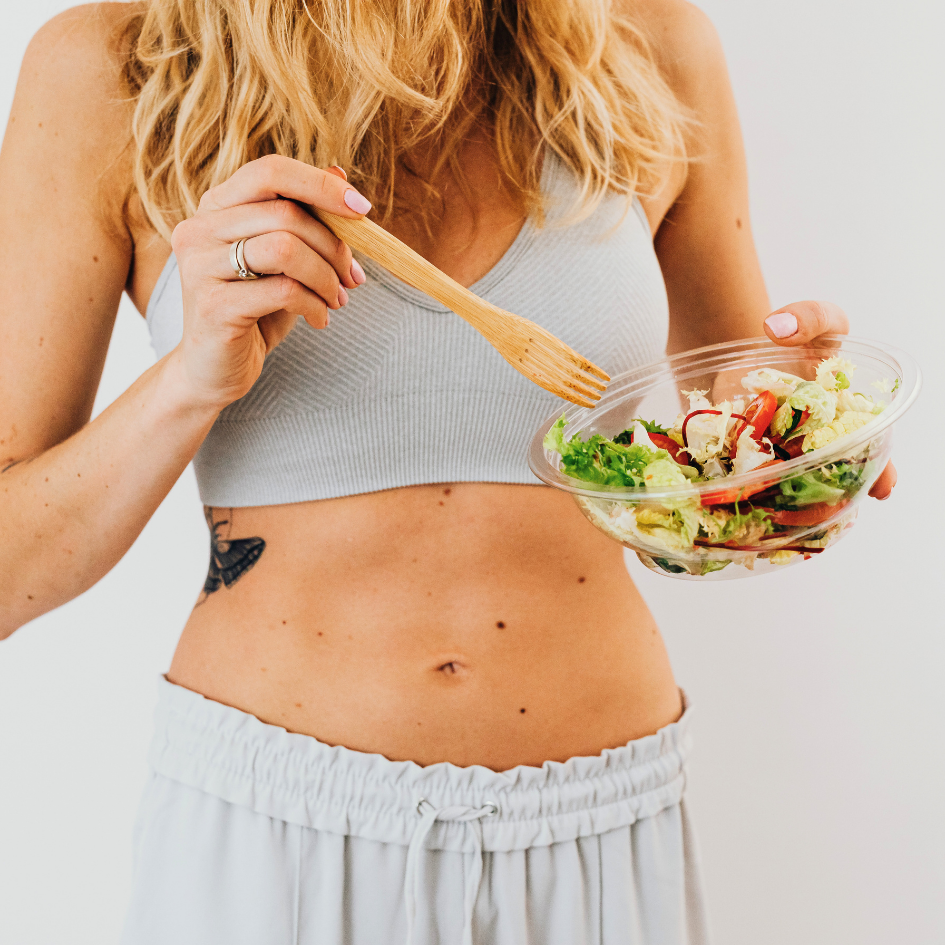 Žena uz lagani nutritivni obrok i fitness opremu pokazuje koliko je pravilna prehrana prije treninga važna za energiju, izdržljivost i kvalitetnije rezultate tijekom tjelovježbe.