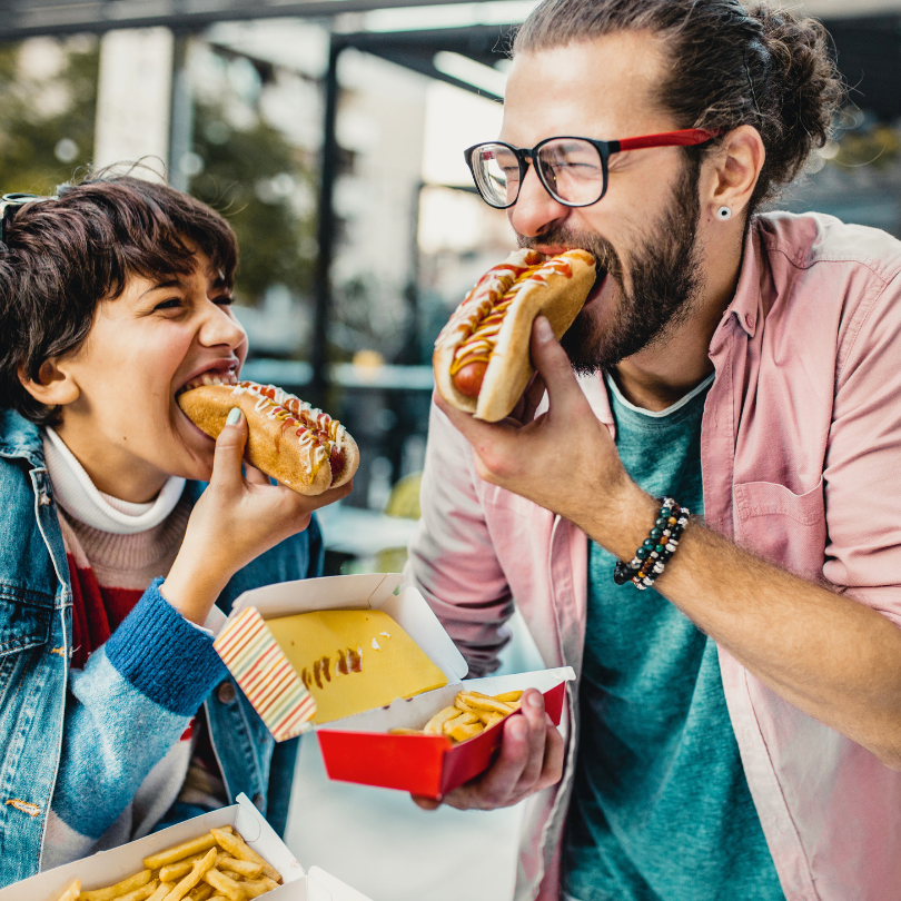 Roditelj i dijete konzumiraju brzu hranu, prikazujući kako fast food postaje dio svakodnevice i može povećati rizik od debljanja te drugih zdravstvenih problema.