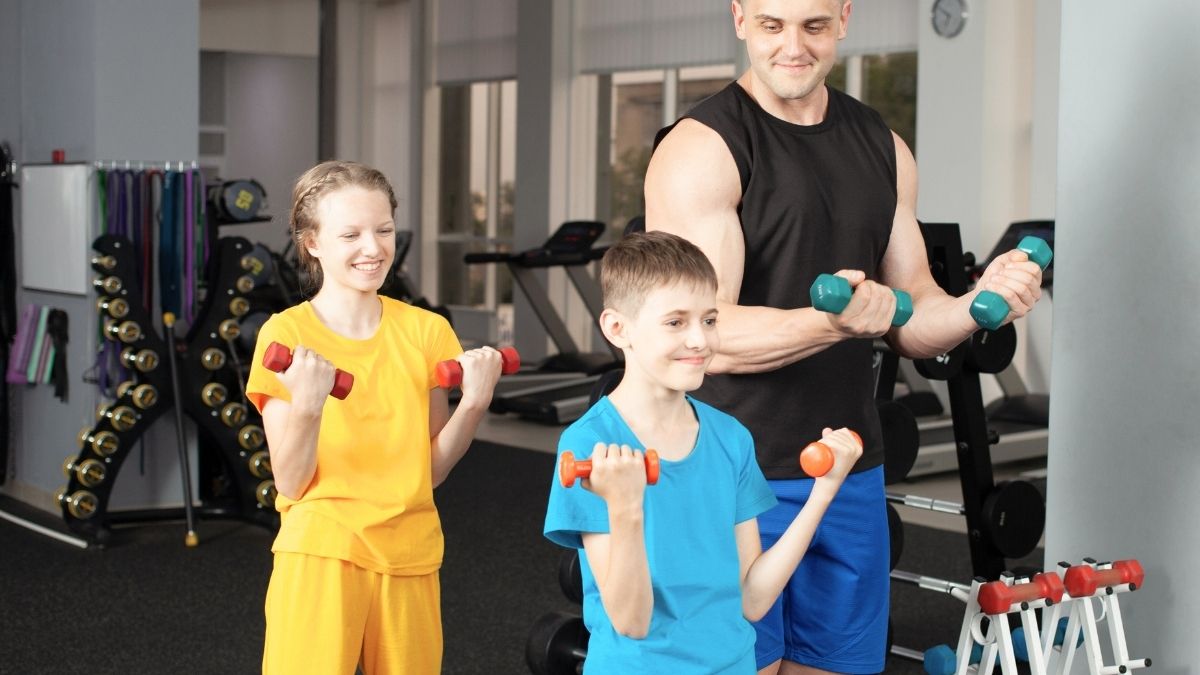 Djeca treniraju s bučicama u teretani uz stručno vođenje trenera