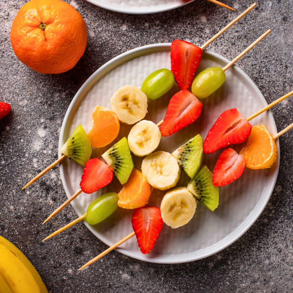 Voćni ražnjići od banane, jagoda, kivija, grožđa i mandarine – primjer zdrave i šarene užine za djecu koja potiče unos vitamina i energije tijekom školskog dana.